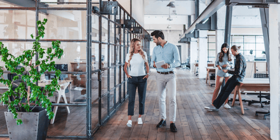 four people talk to each other in the office